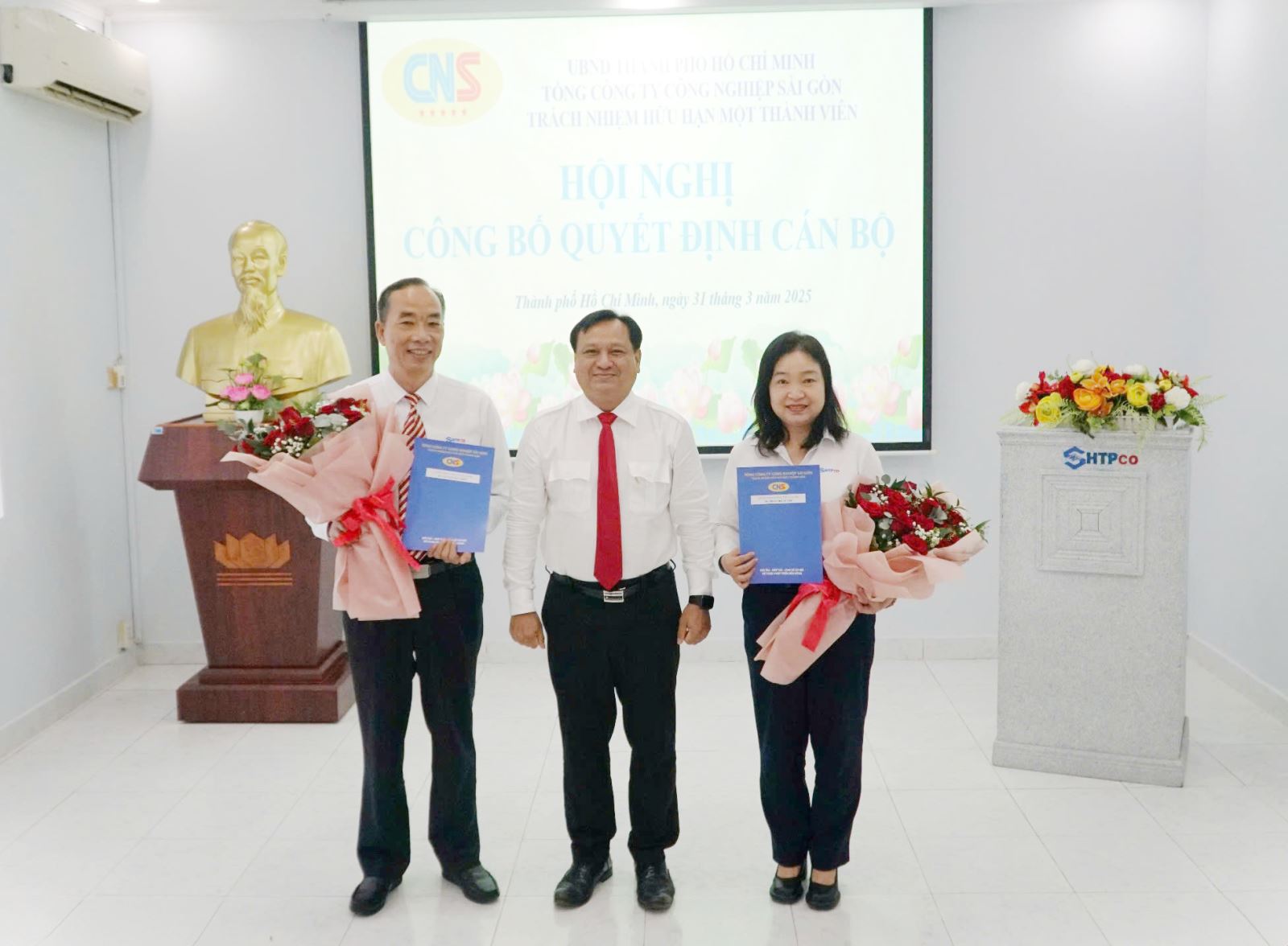 Đồng chí Trần Phi Long, Bí thư Đảng ủy, Chủ tịch HĐTV Tổng Công ty trao quyết định và tặng hoa cho đồng chí Nguyễn Đức Hiền, Trần Thị Lệ Chi